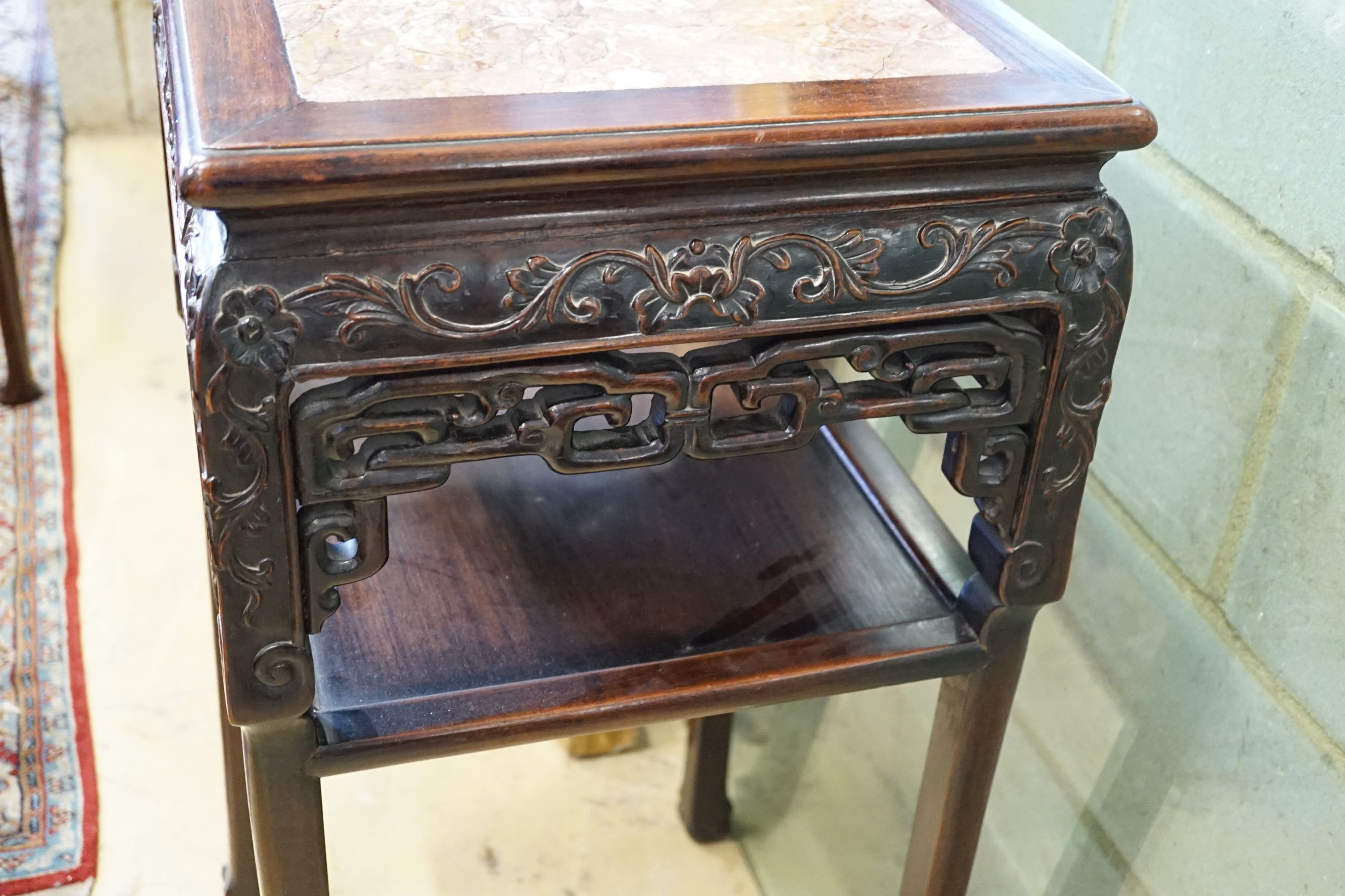 A Chinese carved hardwood rouge marble topped two tier vase stand, width 41cm, height 81cm